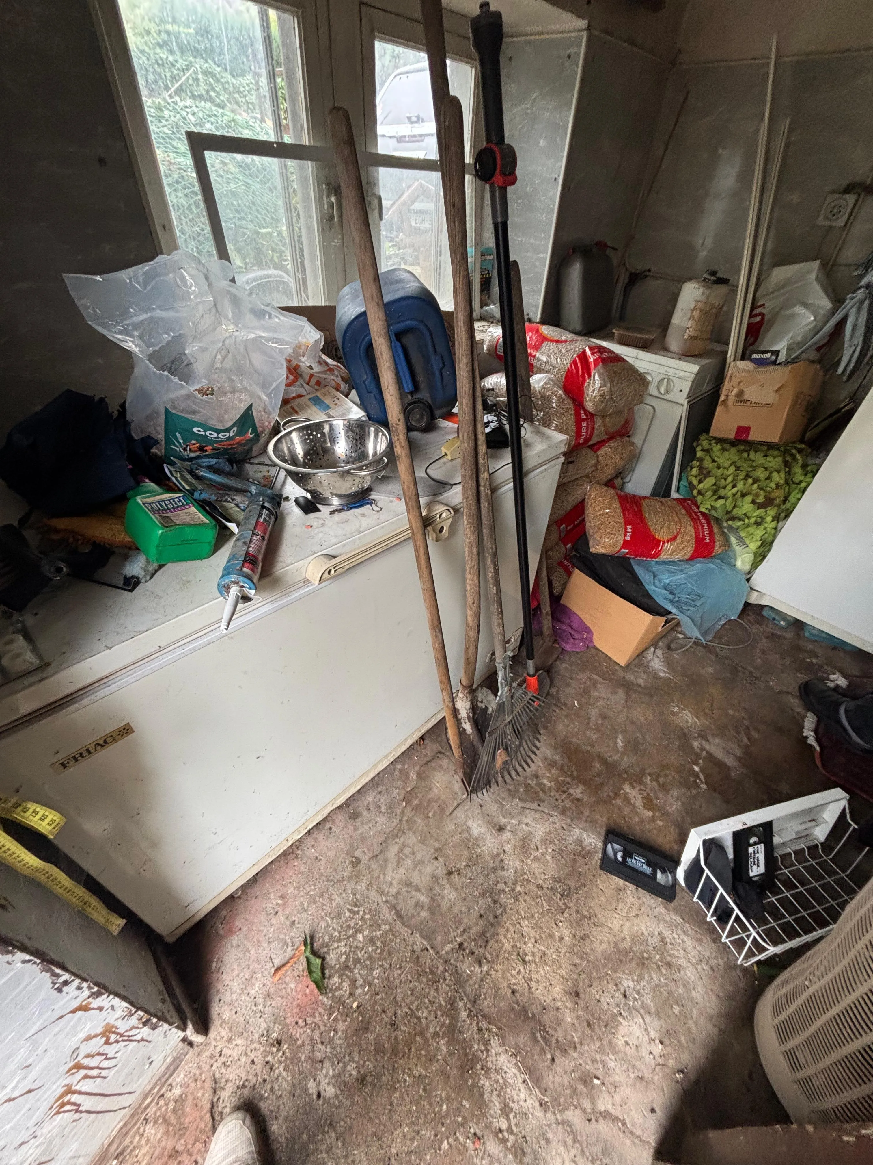 Garage encombré rempli d'outils et de cartons avant intervention
